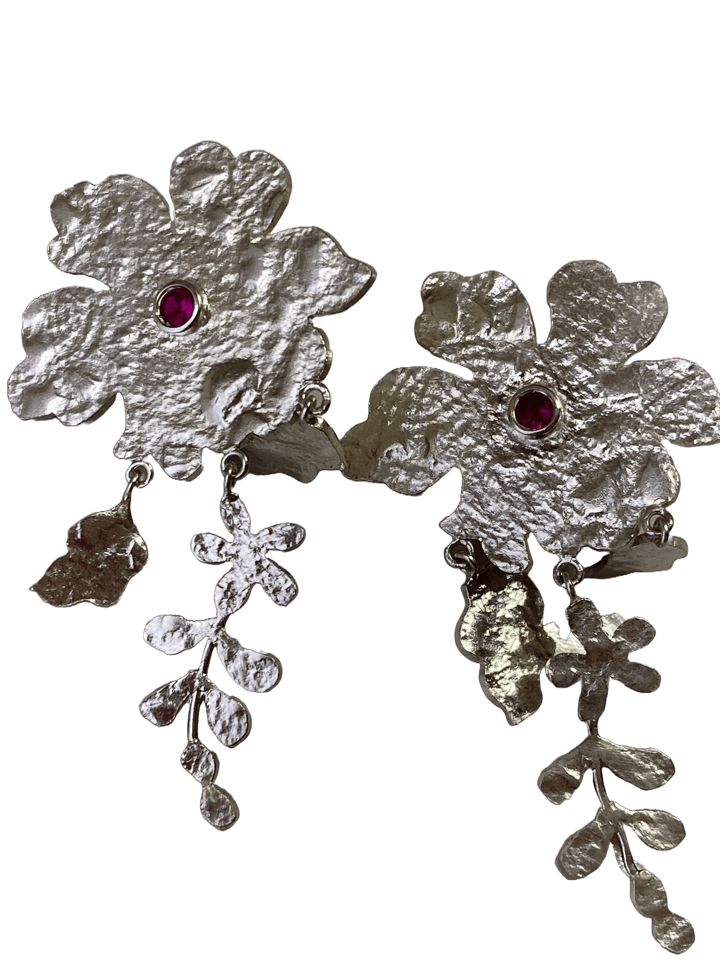 Silver flower and leaf-shaped earrings with dark pink gemstones on a white background