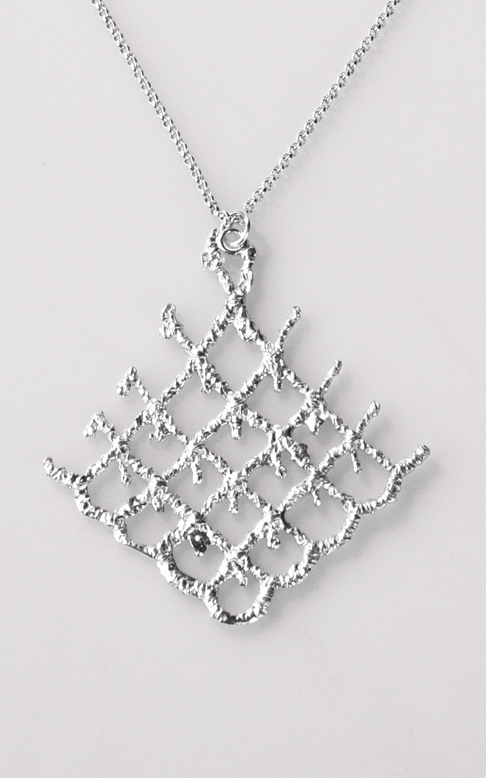 Silver necklace with a geometric pendant on a light gray background
