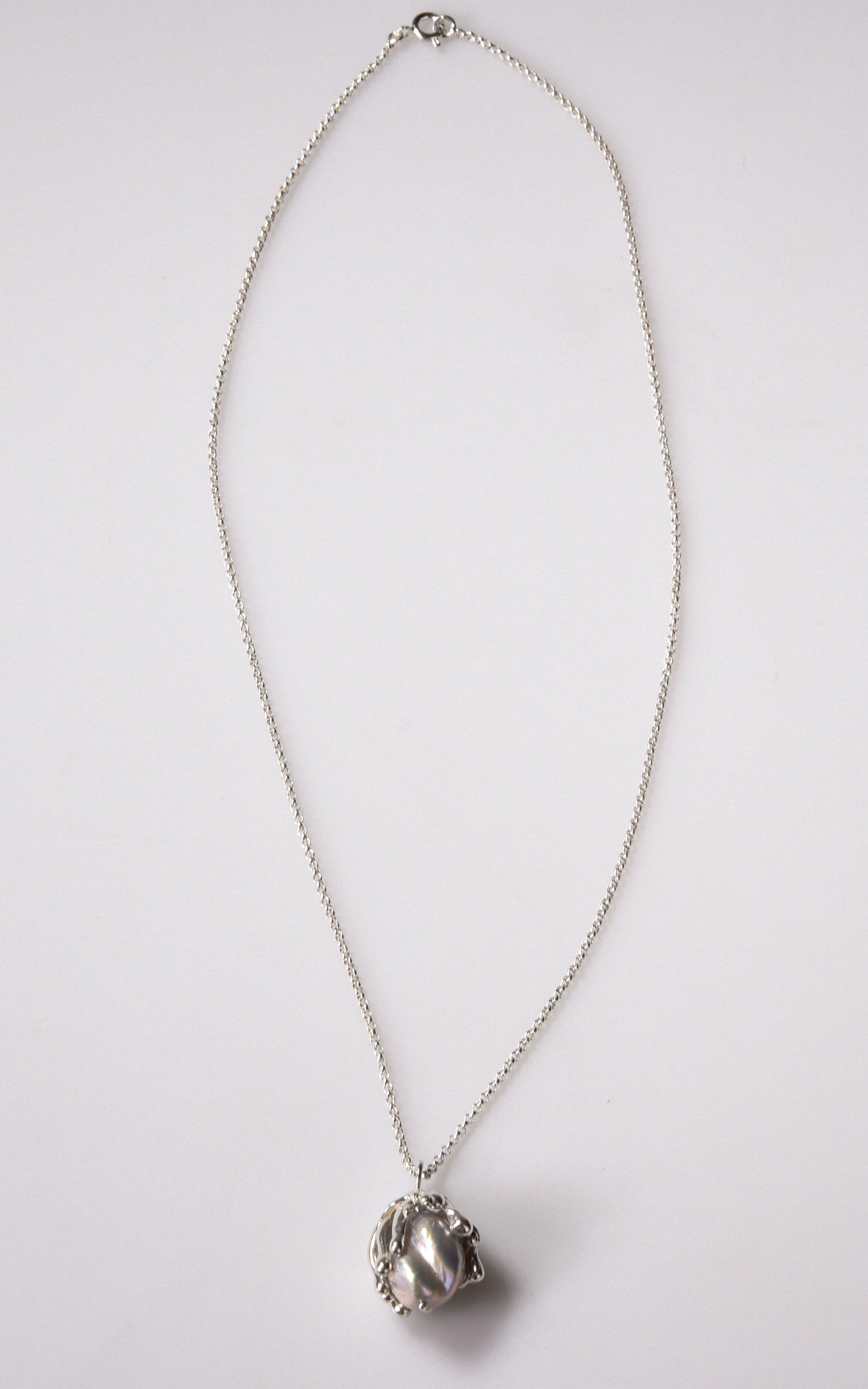 Organic sea inspired handmade sterling silver pendant with baroque pearl on light gray background